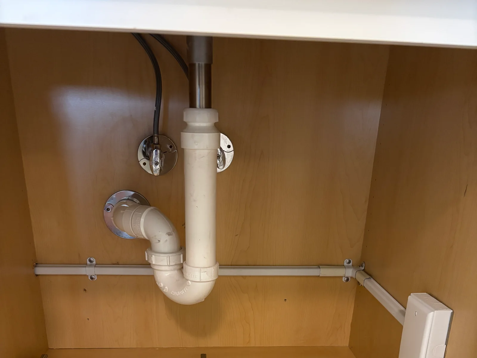 Electrical cable secured beneath a bathroom vanity cabinet