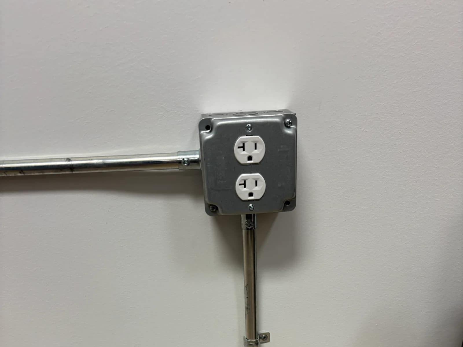 Commercial conduit routed vertically and horizontally around a finished wall corner