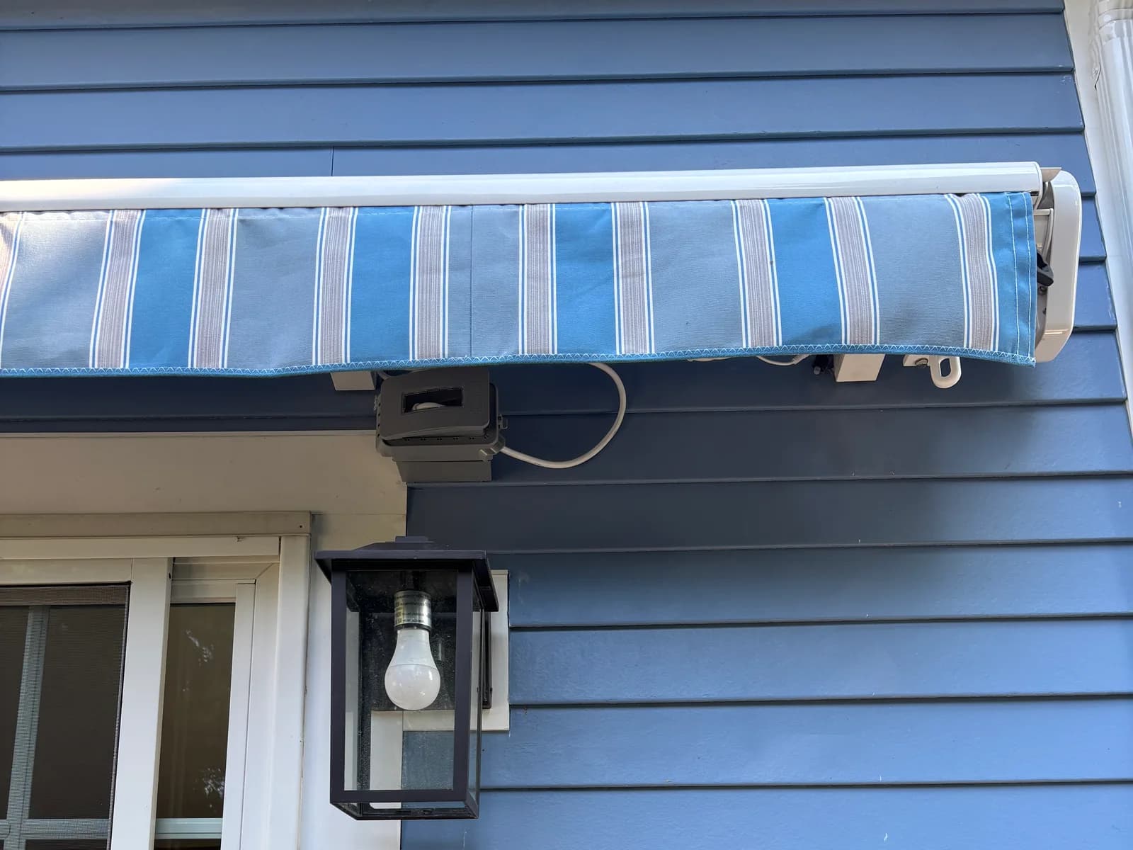 Weather-resistant electrical device installed on blue exterior siding