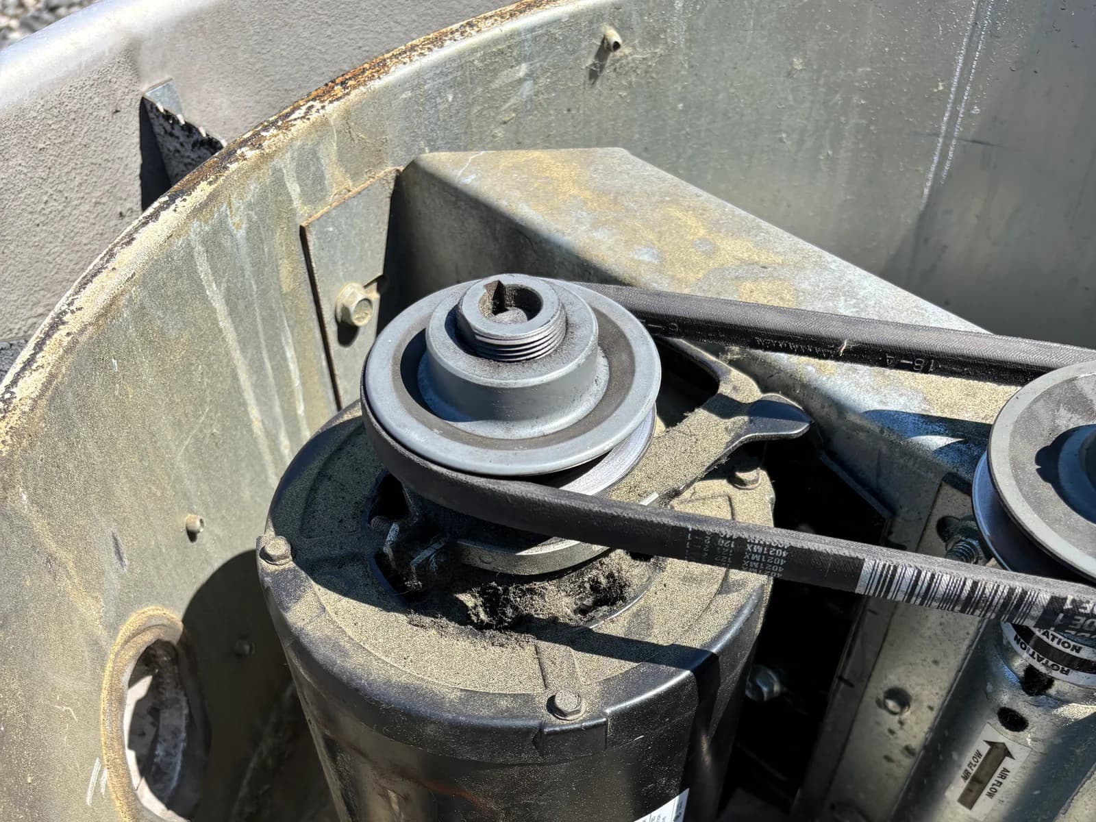 Open outdoor HVAC equipment showing the motor and internal electrical components
